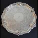 A heavy 19th century salver; the pie crust-style edge with six cast foliate leaves slightly raised
