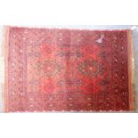 A 20th century Afghan rug; predominately red ground with two central lozenges (150cm x 101cm)