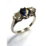 A sapphire and diamond three-stone ring, the central circular mixed-cut sapphire with a brilliant-