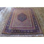 A large hand-knotted Indian carpet by Obeetee of Mirzapur; central cobalt-blue lozenge with flower-