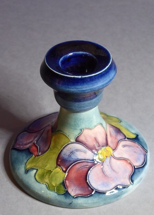 An early 20th century William Moorcroft Pottery squat candlestick in the Hibiscus pattern; Moorcroft