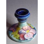 An early 20th century William Moorcroft Pottery squat candlestick in the Hibiscus pattern; Moorcroft