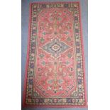 A Turkish hand-knotted rug, predominately red ground (186cm x 95cm)