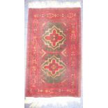 A small Afghan rug with red ground (96cm x 58cm)