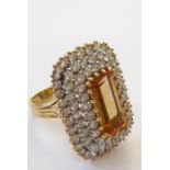 A topaz and diamond-set dress ring, the elongated rectangular-cut cornered topaz set above a three-