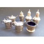 An Art Deco style three-piece hallmarked silver cruet set together with two other slightly larger