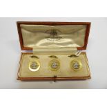 A cased set of three gold buttons with fasteners; base-metal motifs of George slaying the dragon,