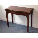 A mid-18th century serpentine-fronted mahogany fold-over top card table; green-baize interior