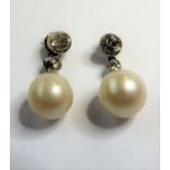 A pair of cultured pearl and diamond-set ear pendants; each designed as a cultured pearl