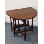 An antique oak drop-leaf gate leg table of small proportions; the oval top mounted on a (probably)