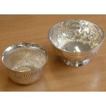 A hallmarked silver circular sugar bowl decorated repoussé style with floral swags and on