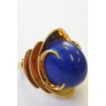 A stylish 1960s lapis lazuli dress ring, the oval lapis cabochon set above a concave navette