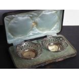 A cased pair of hallmarked silver flowerhead-shaped reticulated dishes (each 11.5cm diameter) (