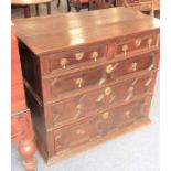 A late 17th century oak chest; the two half-width over three-width graduated drawers with