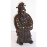 A heavy patinated Chinese bronze figure of a male warrior with long robes and a sheathed sword