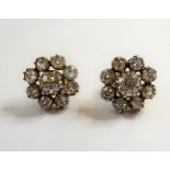 A pair of diamond-set cluster earrings each centrally set with an old brilliant-cut diamond to the