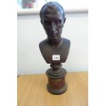 A 19th century patinated bronze bust of Julius Caesar on a variegated rouge marble circular socle
