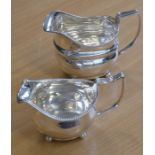 Two hallmarked silver cream jugs both assayed London early 19th century, both on four ball feet (the