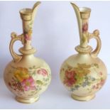 An opposing pair of early 20th century Royal Worcester blush porcelain ewers; each delicately hand