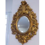 A 19th century-style carved gilt-wood framed wall-hanging looking glass having hand-bevelled oval