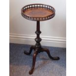A small George III style circular mahogany kettle stand; the galleried balustrade top above turned