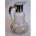 A hallmarked silver-mounted claret jug; the flat hinged cover above a pear-shaped crystal body