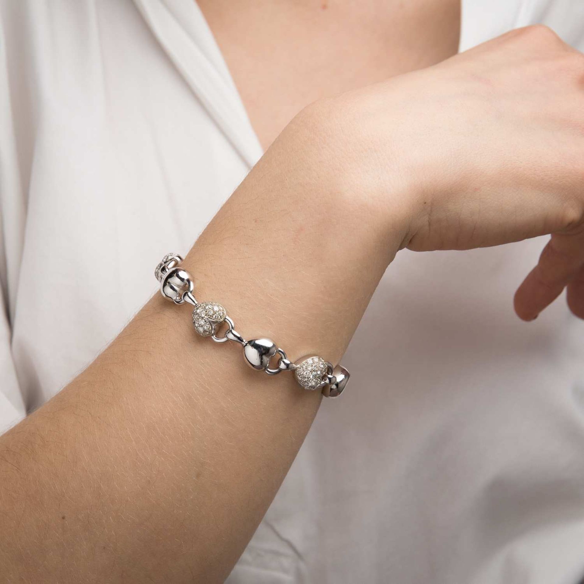 BRACELET COEURS DIAMANTS Il est orné d'une suite de motifs coeurs bombés, trois sont pavés de