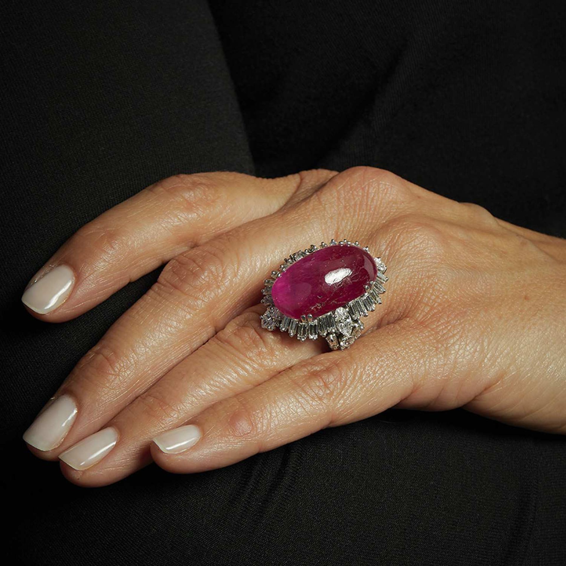 ANNEES 1960 IMPORTANTE BAGUE RUBIS CABOCHON Le rubis cabochon ovale allongé est entouré d'un décor