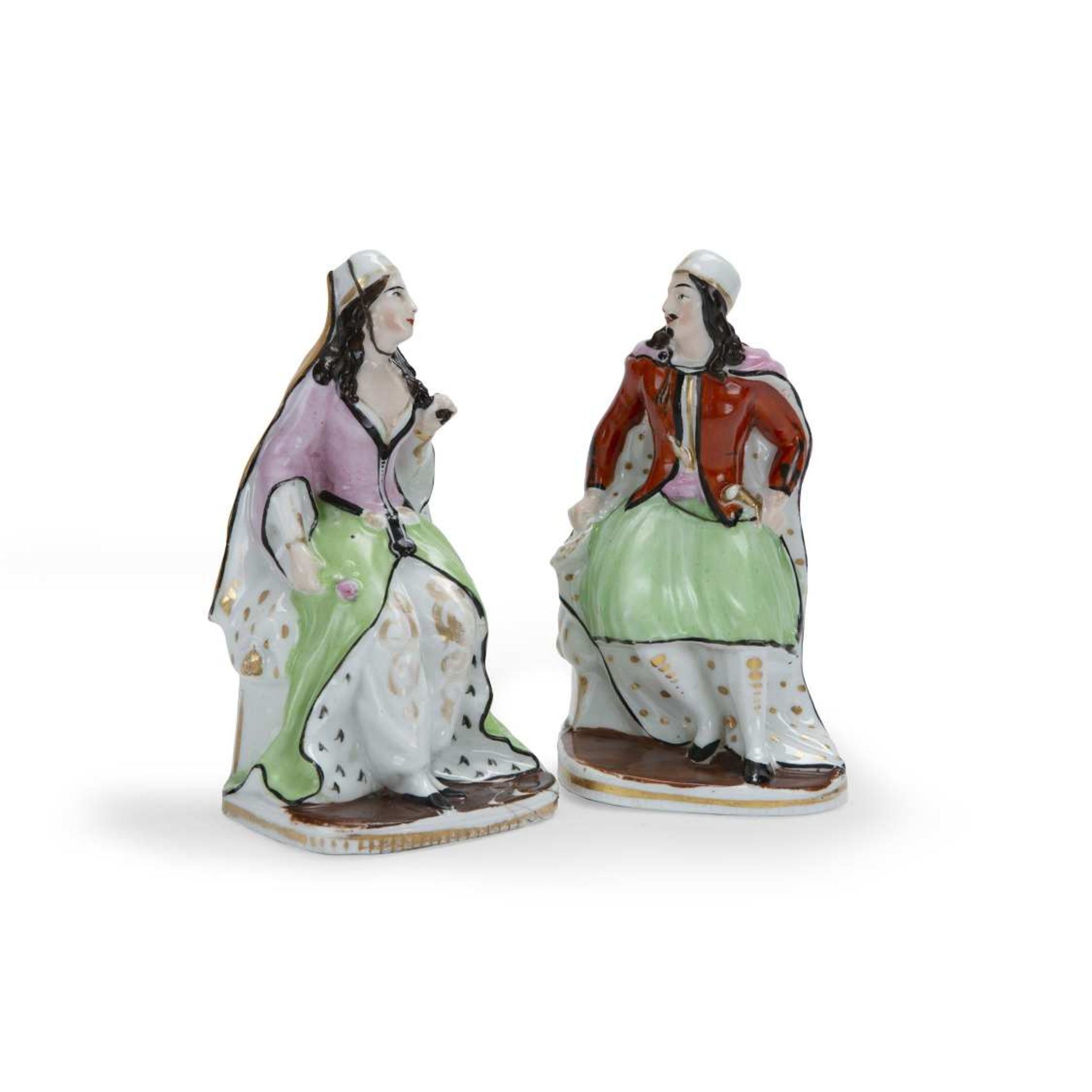 COUPLE DE GRECS ASSIS Deux flacons-statuettes en porcelaine polychrome (Eclats à la base ; Tête de