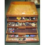 A wooden drawered box of buttons, needles and other items for needlework