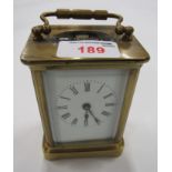 A brass cased carriage clock with white dial and key.