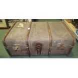 A wood bound travelling trunk with leather handles and inner lift-out tray