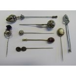 A collection of eight stick/hat pins to include a marked silver Scottish design stick pin hallmarked