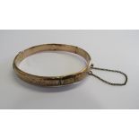 A George V rose gold half foliate patterned bangle with intact safety chain, bangle diameter 6 1/