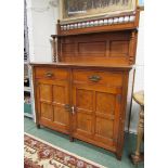 An Edwardian oak dresser with over mantle shelf on spindles, two drawers above two cupboards