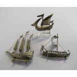 A marked 925 silver miniature ship on a stand together with two white metal miniature ships (no