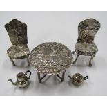 A collection of unmarked silver (tested) miniature dolls house furniture comprising of two
