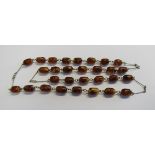 An art deco/retro pressed Baltic amber necklace comprising of 29 barrel shaped beads of cognac