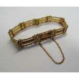 A 15ct gold slide clasp ornate, finely made three bar gate bracelet with attached safety chain. Back