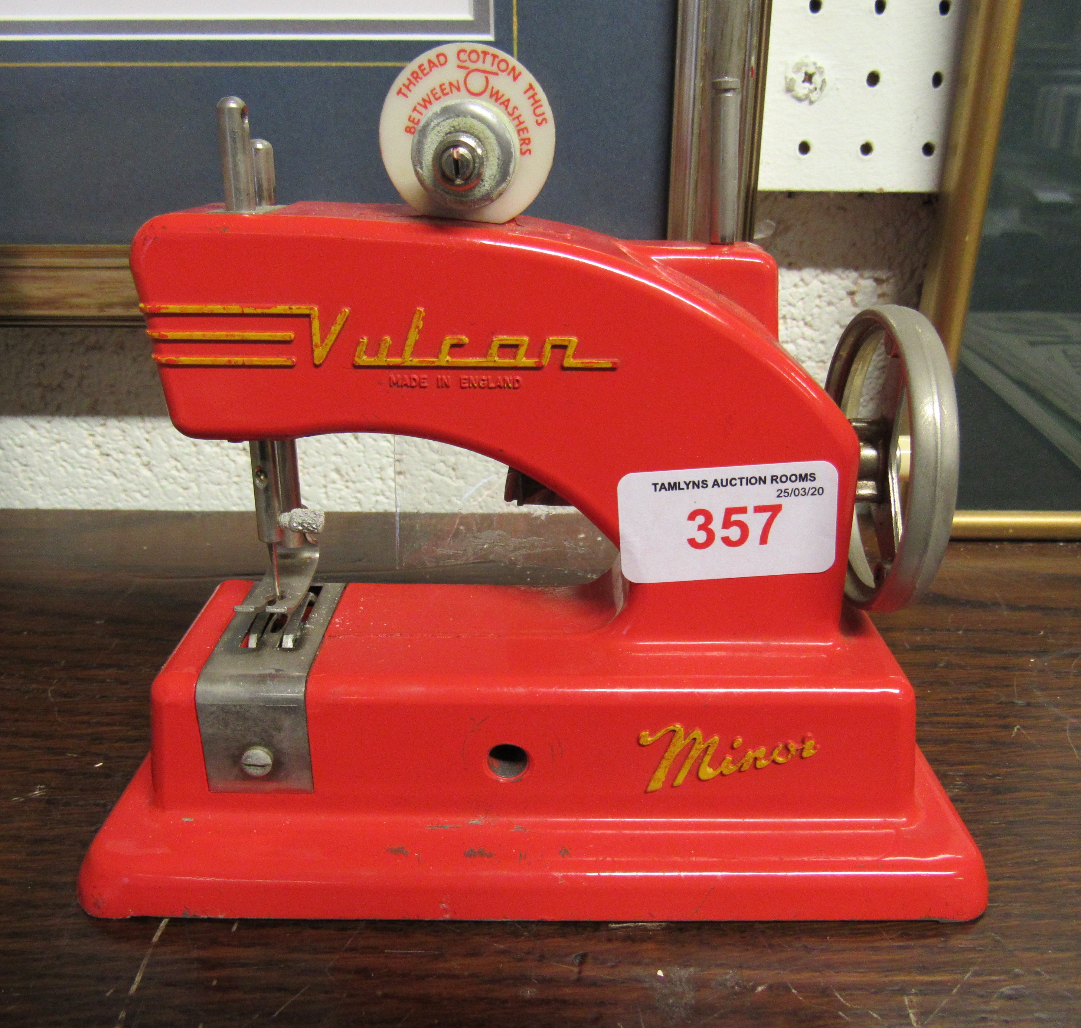 A children's tinplate Vulcan red sewing machine