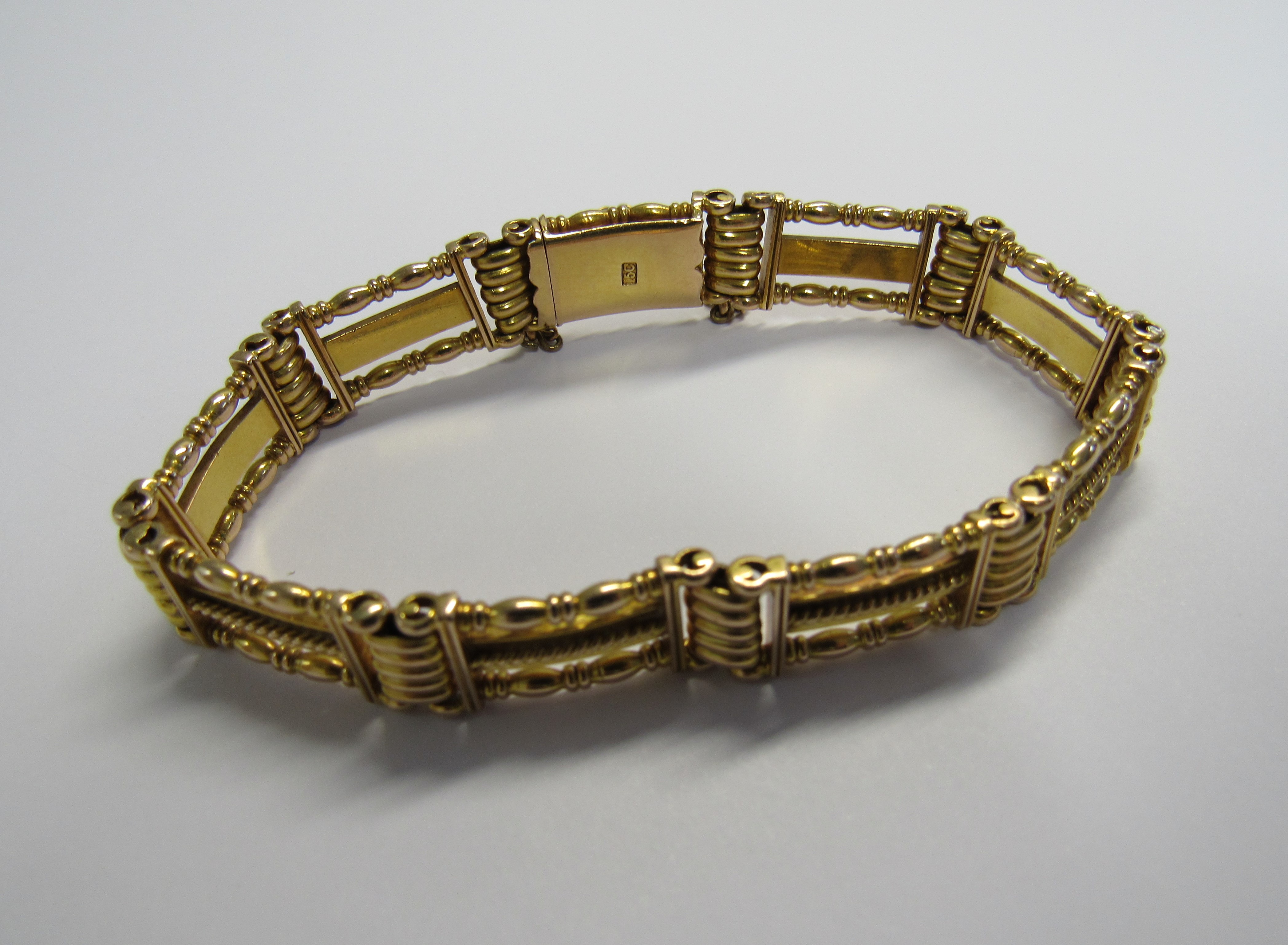 A 15ct gold slide clasp ornate, finely made three bar gate bracelet with attached safety chain. Back - Image 2 of 2