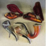 A collection of smoking pipes, two with silver decoration, one which is a Sherlock Holmes style.