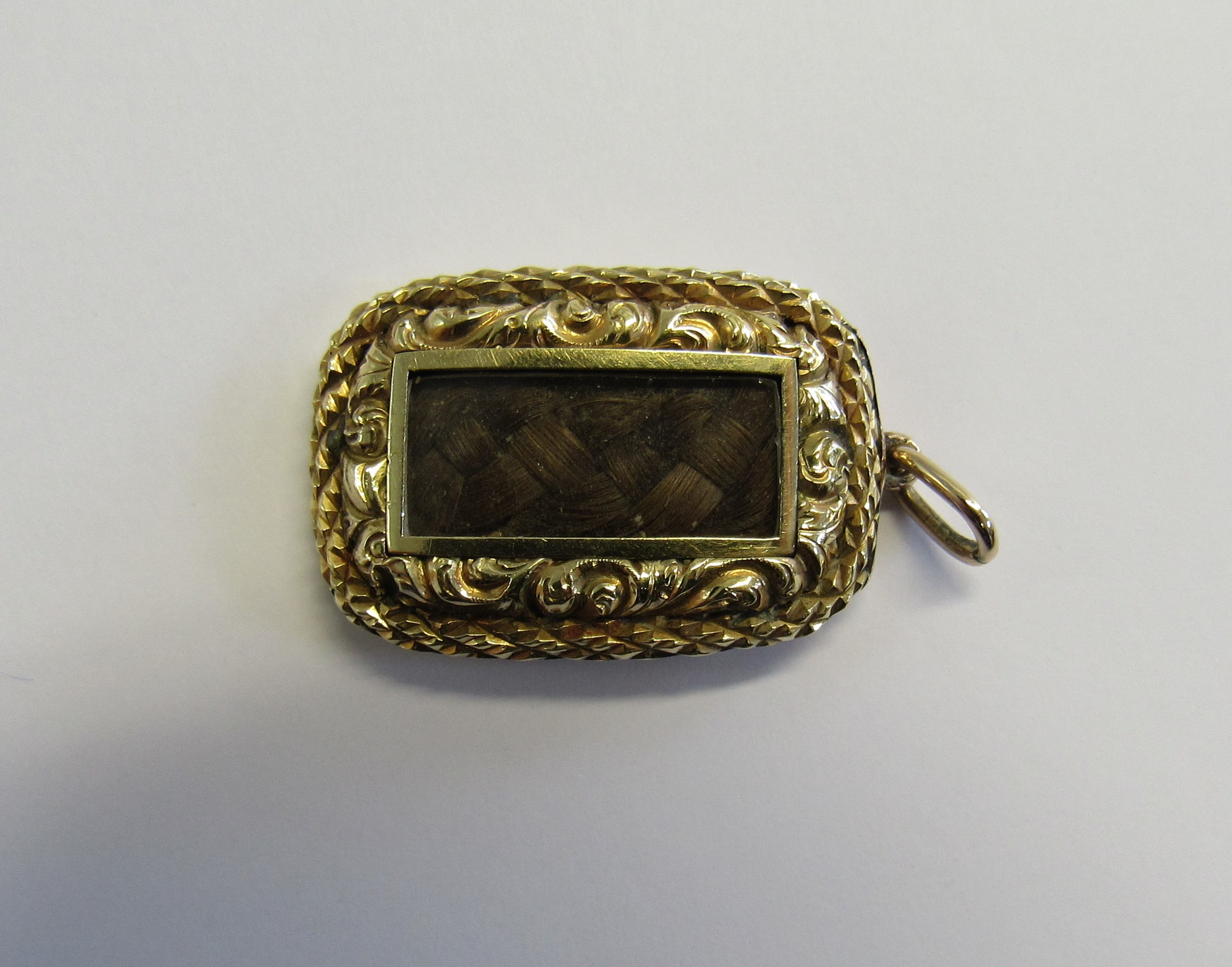 Memorial - A Victorian unmarked gold (tested) pendant piece of oblong form set with a glass