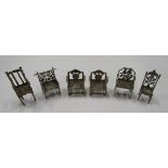 A collection of six silver miniature dolls house chairs, unmatched but with semi backs,