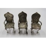 Three silver miniature dolls house high backed chairs, in similar repousse style of embossed
