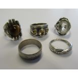 A collection of five marked silver or marked 925 rings to include a cabochon set tigers eye. Ring