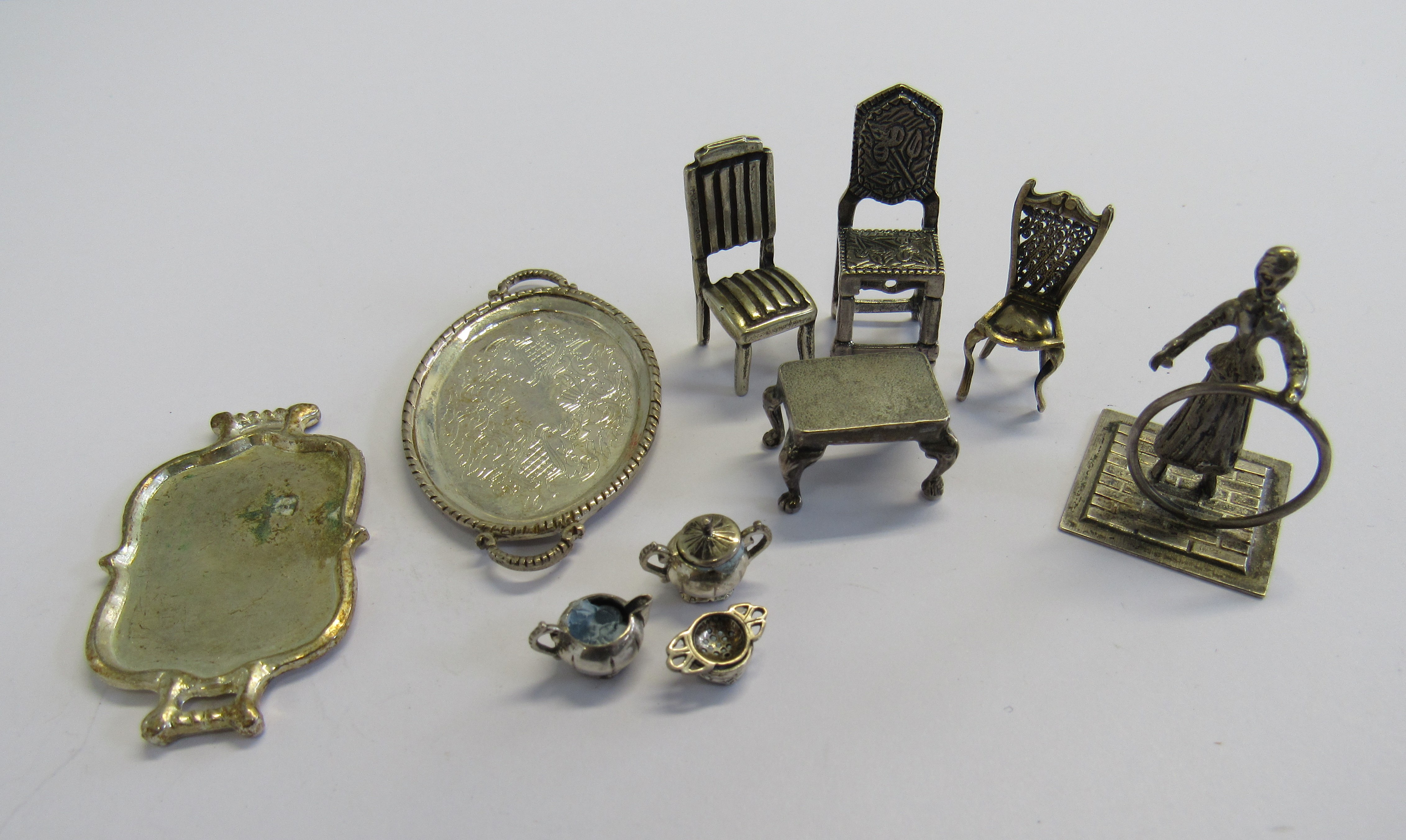 A collection of unmarked white metal micro miniature dolls house items comprising of three dining