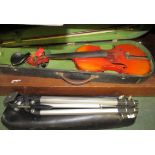 A cased violin with music stand