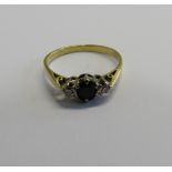 A marked 18ct gold, diamond and sapphire dress ring with the central set faceted oval sapphire