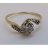 An 18ct gold, platinum and old cut diamond solitaire cross over ring with two tiny old cut